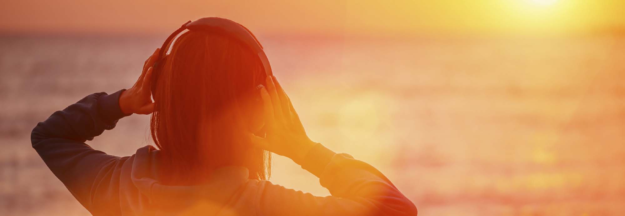 Young woman enjoying beautiful sunset over the sea